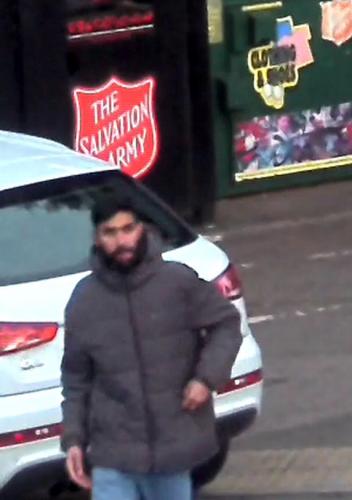 Man in grey jacket walking away from clothing bank