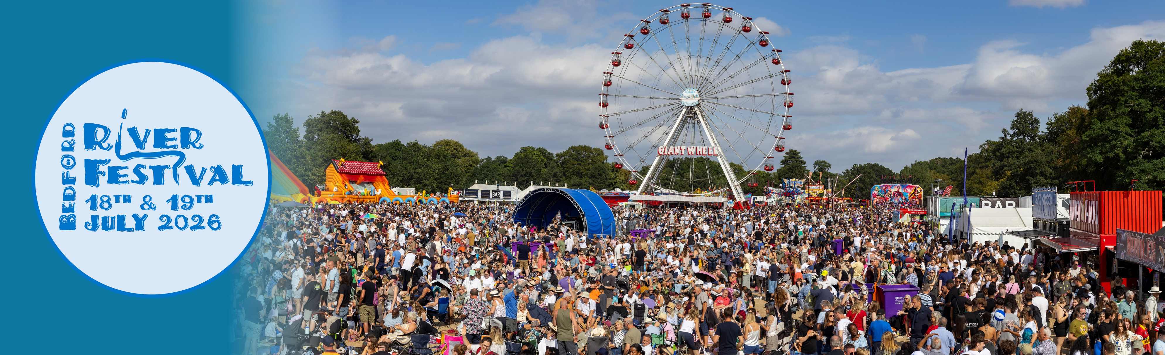 Crowds of people at River Festival event with Ferris wheel in background