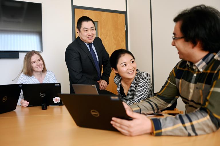 Two female and two male members of staff in a work setting