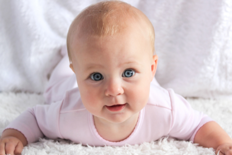 Baby on its front looking at camera