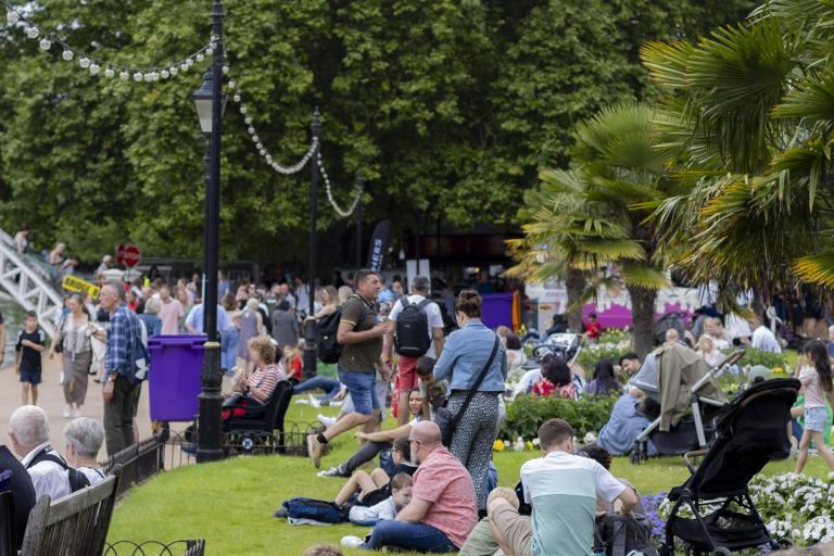 Crowd of people relaxing on grass