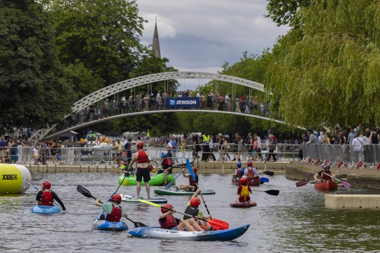 Lots of people paddling canoes in river