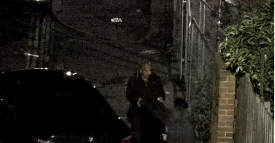 Male dressed in black holding a dark item in front of his body