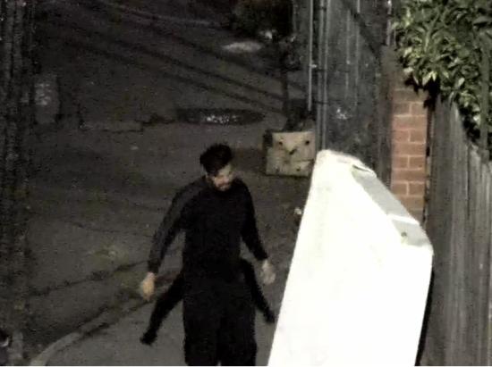 Male dressed in black standing next to white mattress on the pavement