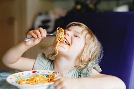 Girl eating food at dinner table