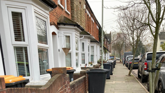 Wheelie bins on the path outside houses on a residential street