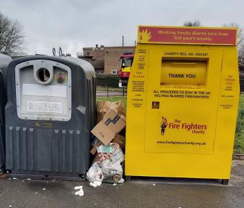 Waste dumped between a bottle bank and clothes bank