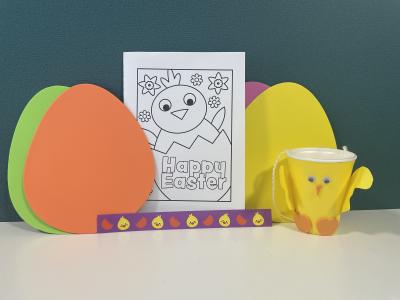 Examples of Easter Crafts at Bedford Borough Libraries. A card to colour, wristband, and a plastic cup made to look like a chick