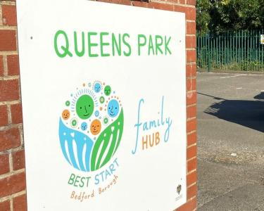 The sign outside the Queens Park Family Hub, which reads "Queens Park Family Hub. Best Start Bedford Borough."