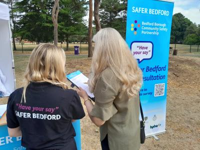 Bedford Borough Community Safety Officer speaking with a resident about completing a survey.