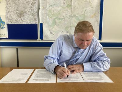Jon Shortland, Chief Officer for Planning, Infrastructure and Economic Growth, signs Wixams railway station paperwork