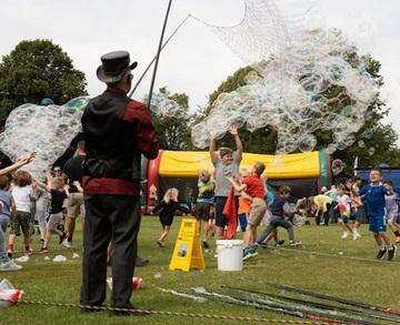 Bubble man creating bubbles in a park