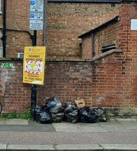 Fly-tipping of bin bags on a street