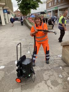 Cllr Gribble removing chewing gum from the pavement