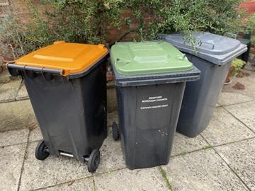 Orange, green and black lidded wheelie bins