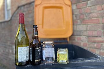 Orange-lidded bin with glass bottles and jars