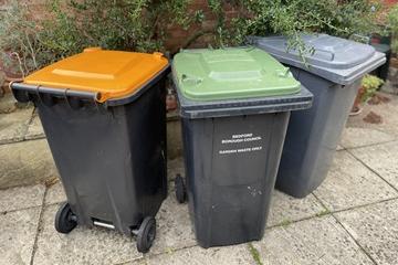 Orange, green and black lidded wheelie bins