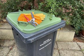 Green lidded bin with gloves on top