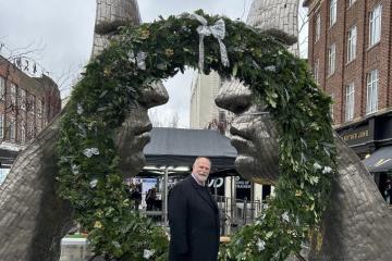 Mayor of Bedford Borough, Tom Wootton, in front of the Christmas wreath on the Silver Faces statue