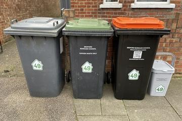 Residential bins on street - black bin, green-lidded, orange-lidded, grey food caddy
