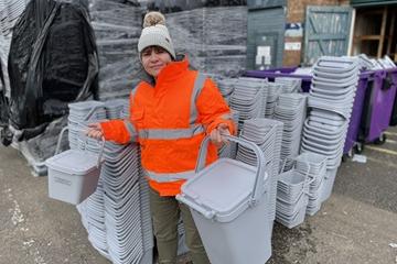 Councillor Nicola Gribble with a kitchen caddy and outdoor bin for food waste 