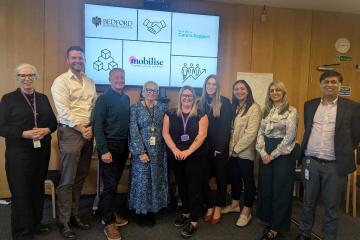 Staff and partners line up to celebrate the new partnership